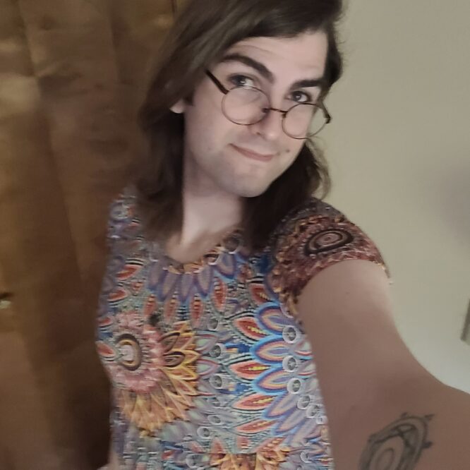 Person selfie wearing colorful patterned dress and glasses