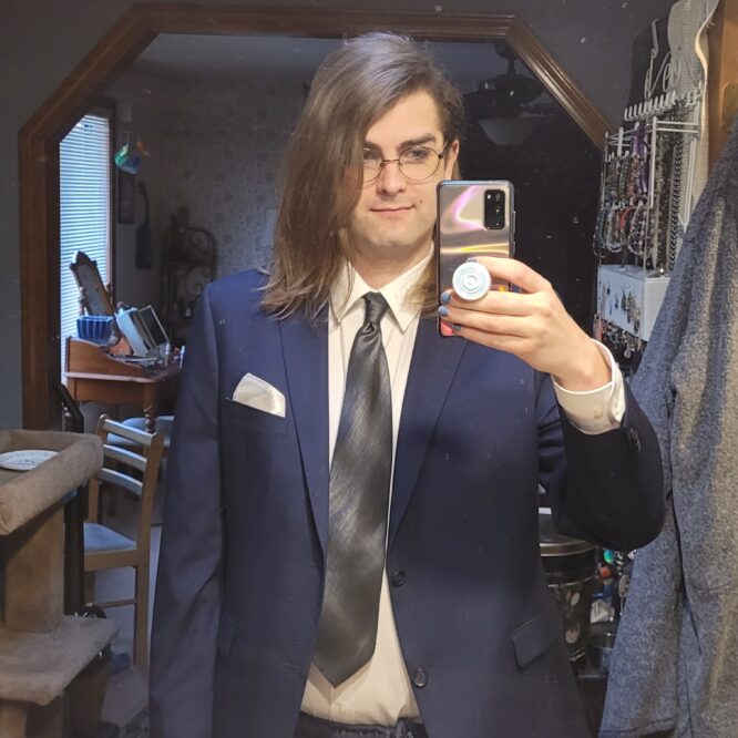 Person in suit taking mirror selfie