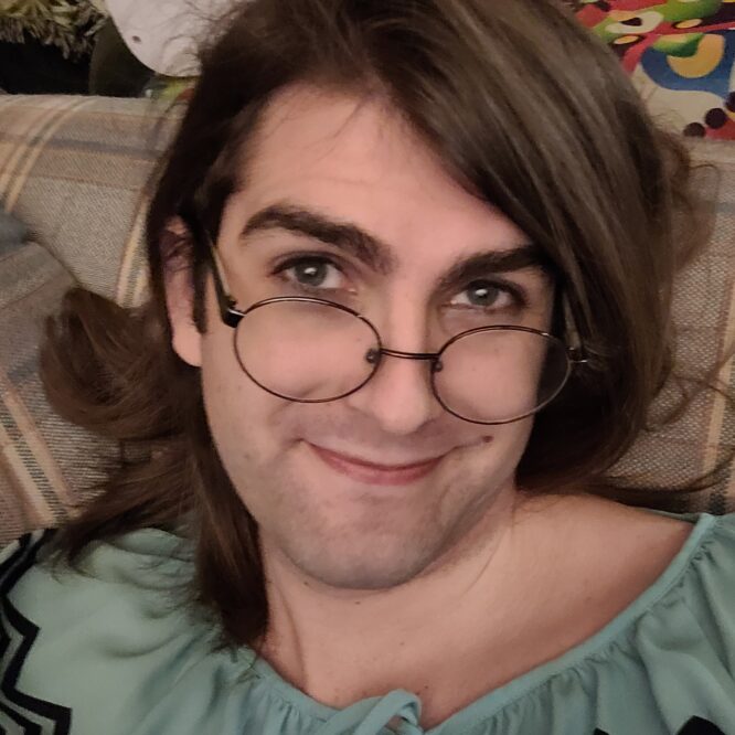 Smiling person with glasses on couch