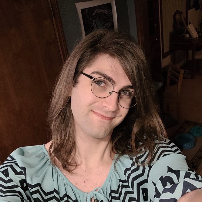 Smiling person with glasses and long hair