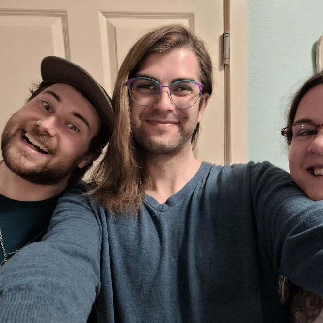 Three friends smiling for a selfie indoors