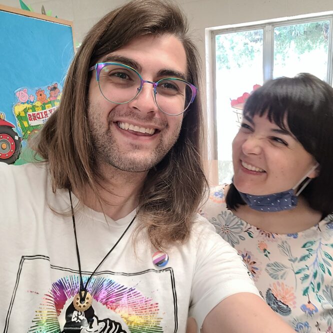 Two smiling people taking an indoor selfie