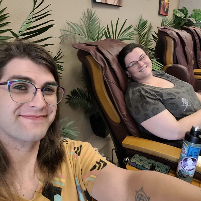 Two people relaxing in massage chairs at spa