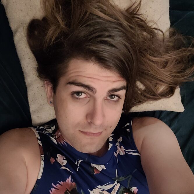 Person with long hair lying, wearing floral top