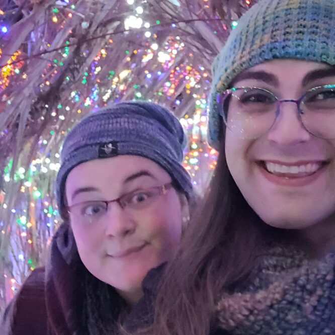 Two smiling people in colorful light tunnel