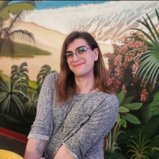 Smiling person wearing glasses in tropical mural