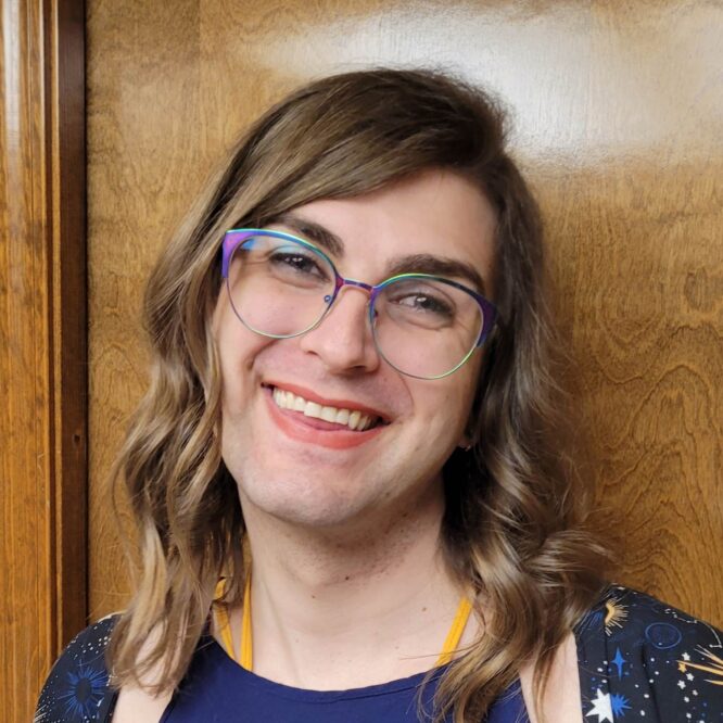 Smiling person wearing colorful glasses, wavy hair